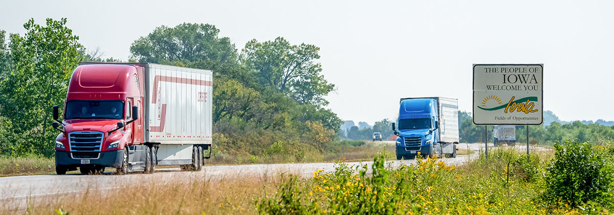 Crete and Shaffer trucks run on a westward stretch of highway across the Iowa / Nebraska state line.