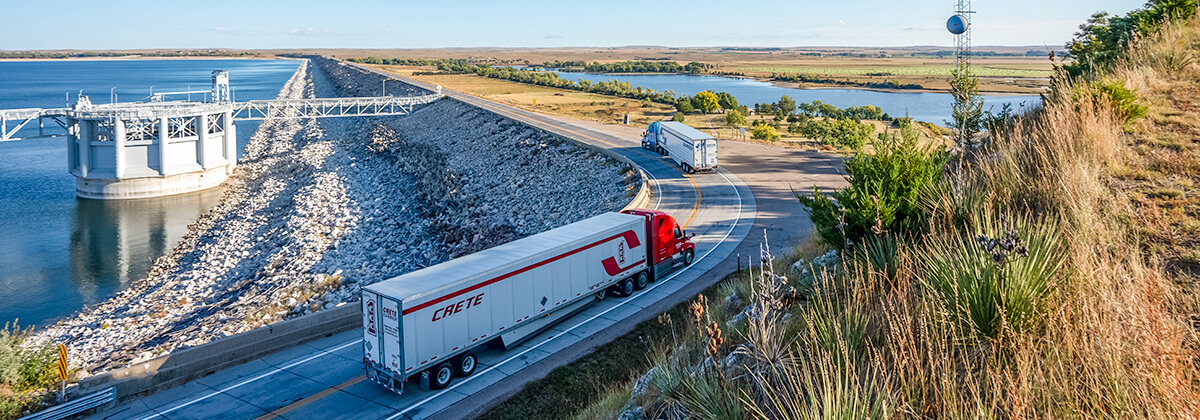 Crete Carrier and Shaffer Trucking trucks roll onto the Lake McConaughy dam north of Ogallala, Nebraska