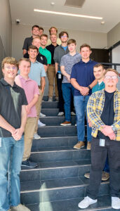 A group of 2022 summer interns pose in the stairwell of the Lincoln driver terminal building